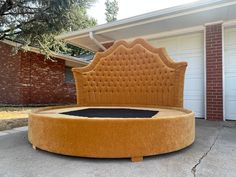 a round bed sitting on top of a cement slab in front of a garage door