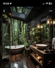 a bathroom with a tub, sink and large mirror in it's center surrounded by greenery