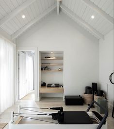 a living room with white walls and wood flooring on the ceiling is filled with black furniture