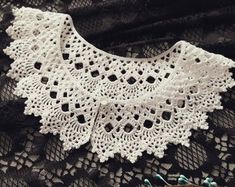 white crocheted lace on black fabric with small beaded beads and twig