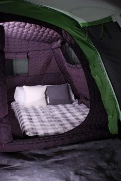 the inside of a tent with a bed in it