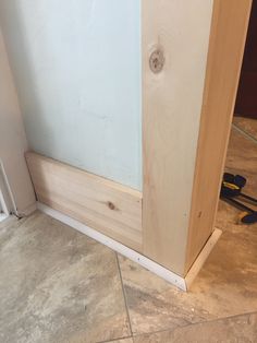 the corner of a room that is being built with plywood and wood on the floor