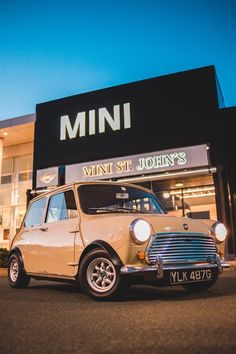 an old mini parked in front of a store