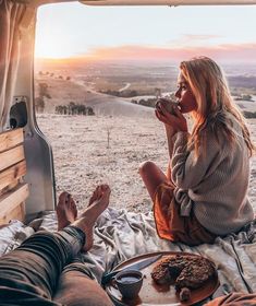 a woman sitting on top of a bed next to a man who is eating food