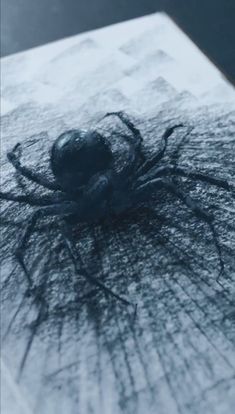 a spider sitting on top of a piece of paper with black ink all over it