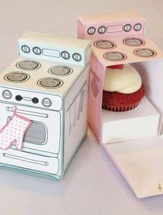 a cupcake in a box next to an open cardboard box with the door open