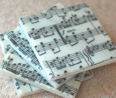 four coasters with musical notes on them sitting on a carpeted floor next to each other