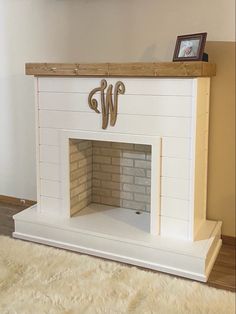 a white fireplace with a wooden mantel above it