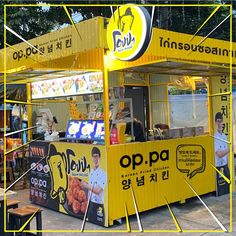 a yellow food cart sitting on the side of a road