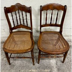 two wooden chairs sitting next to each other