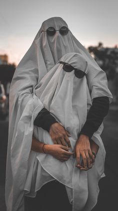 a woman in a white veil and black gloves holding her hands on her hip while walking down the street