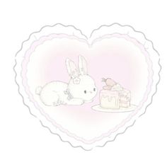 a heart shaped frame with two rabbits and a cake in the shape of a heart