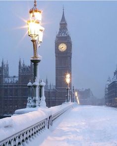 the big ben clock tower towering over the city of london covered in snow at night