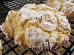 two powdered sugar cookies on a cooling rack