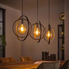 a dining room table with chairs and lights hanging from it's centerpieces