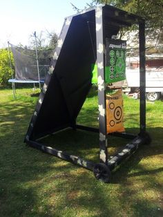 a large black object sitting on top of a lush green field