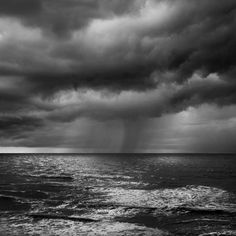 black and white photograph of storm clouds over the ocean