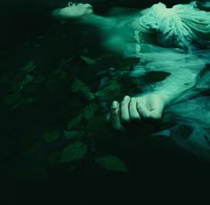 a woman laying in the water with her hands on her chest