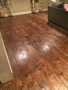 a living room with hard wood flooring and curtains