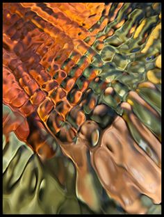 an abstract photograph of water and rocks in orange, green, yellow and brown colors