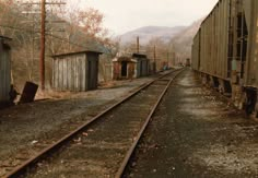 an old train yard with tracks and buildings