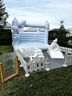 an inflatable bed is set up outside on the grass with balloons and decorations