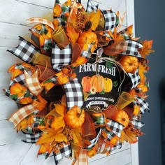 an orange and black wreath with pumpkins on it