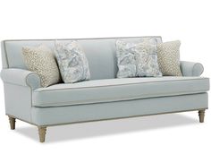 a light blue couch with pillows on the arm and back cushions, sitting in front of a white background