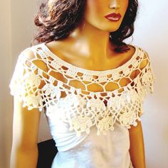 a mannequin wearing a white top with crochet