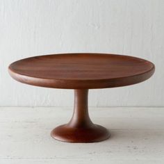 a wooden cake plate sitting on top of a white table