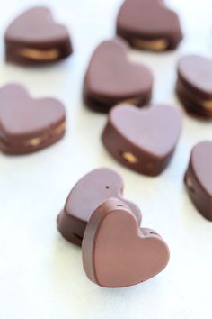 heart shaped chocolates sitting on top of a white table next to each other in the shape of hearts