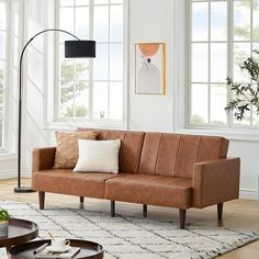 a living room filled with furniture and lots of window sill space next to a coffee table