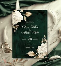 an elegant wedding card with white flowers and leaves on a green satin background, in the style of art deco