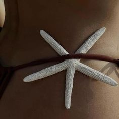 a woman's stomach with a white starfish on it and a brown string