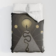 a bed with a black and gold comforter on top of it next to a white pillow