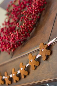 gingerbread cutouts are hanging on the side of a door with candy canes