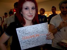 a woman holding up a sign with words all over it