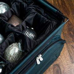 an open suitcase filled with ornaments on top of a wooden floor