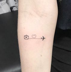 a small tattoo on the arm of a woman with an airplane and heart in it