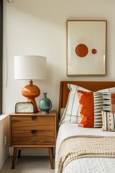 a bed room with a neatly made bed and a painting on the wall above it