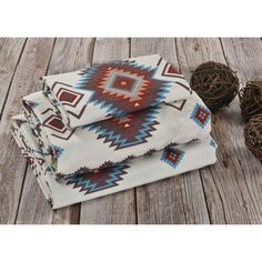 three native style blankets and two balls of twine on a wooden floor with wood planks