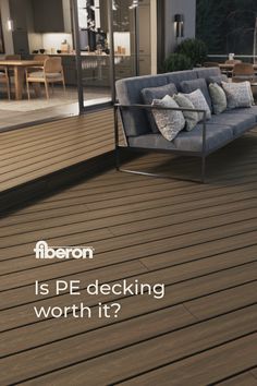 a couch sitting on top of a wooden floor next to a glass wall and patio