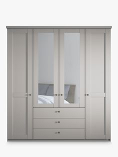 a white wardrobe with mirrored doors and drawers