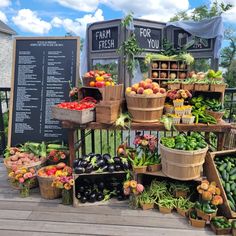 many different types of fruits and vegetables on display at a farmer's market stall