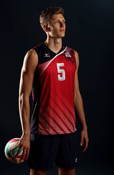 a young man holding a basketball in his right hand and wearing a jersey with the number 5 on it