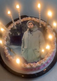 a cake decorated with candles and a photo of a woman