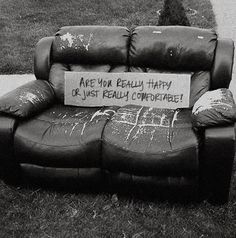 a black and white photo of a couch with a sign on it that says, are your family happy or just really comfortable?