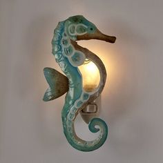 a sea horse is mounted to the wall with a light on it's side