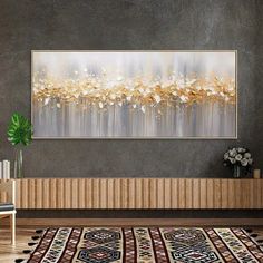 an abstract painting on the wall above a rug in a living room with a plant