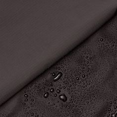 water drops on the side of a dark colored suit with black linings and buttons